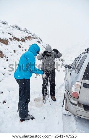 Similar – Image, Stock Photo Woman putting security snow chain in tire wheel of car