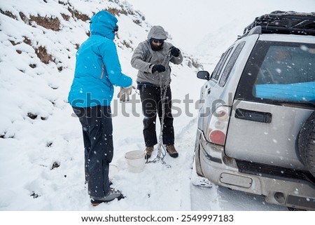Similar – Image, Stock Photo Woman putting security snow chain in tire wheel of car