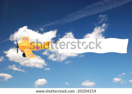 Airplane with banner over blue sky