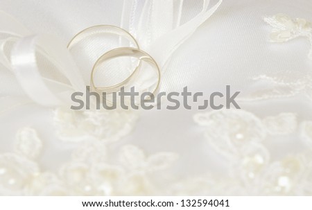 Wedding rings on a white satin pillow