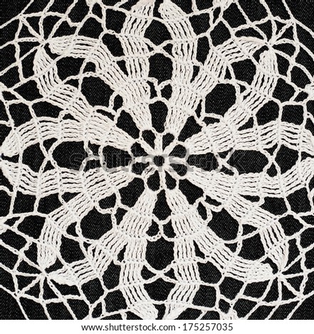 White crochet lace on black background