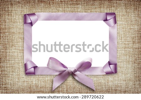 Satin frame with knots and bow on beige canvas background