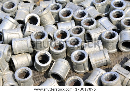Metal plumbing pipe fittings piled up together