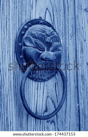 closeup of pictures, metal door knocker on yellow door plank