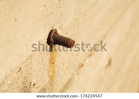 tighten bolts rust on concrete walls, closeup of photo
