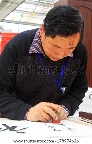 TANGSHAN CITY - FEBRUARY 6: Calligrapher Chen Peiyu seal on the calligraphy work, on february 6, 2014, Tangshan city, Hebei province, China.