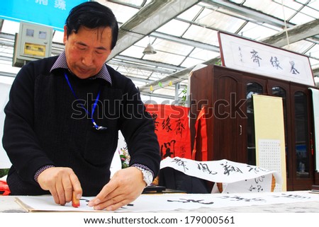 TANGSHAN CITY - FEBRUARY 6: Calligrapher Chen Peiyu seal on the calligraphy work, on february 6, 2014, Tangshan city, Hebei province, China.