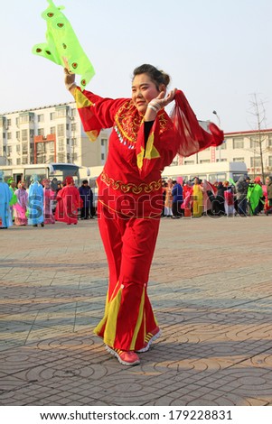 LUANNAN COUNTY, CHINA - FEBRUARY 8: People wearing colorful clothes, performing yangko dance in the street, during the Chinese Lunar New Year, February 8, 2014, Luannan County, Hebei Province, China.