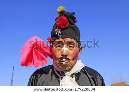LUANNAN COUNTY, CHINA - FEBRUARY 9: Buffoon wearing colorful clothes, performing yangko dance in the street, during the Chinese Lunar New Year, February 9, 2014, Luannan County, Hebei Province, China.