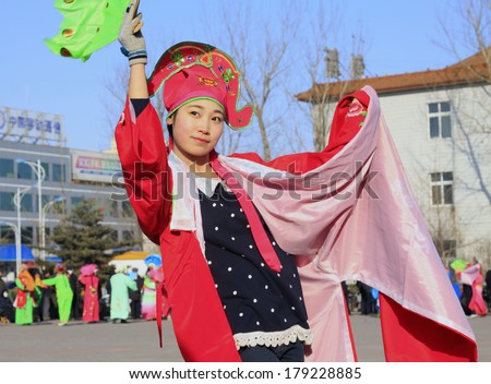 LUANNAN COUNTY, CHINA - FEBRUARY 9: Girl wearing colorful clothes, performing yangko dance in the street, during the Chinese Lunar New Year, February 9, 2014, Luannan County, Hebei Province, China.