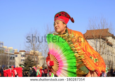 LUANNAN COUNTY - FEBRUARY 9: People wearing colorful clothes, performing yangko dance in the street, during the Chinese Lunar New Year, February 9, 2014, Luannan County, Hebei Province, China.