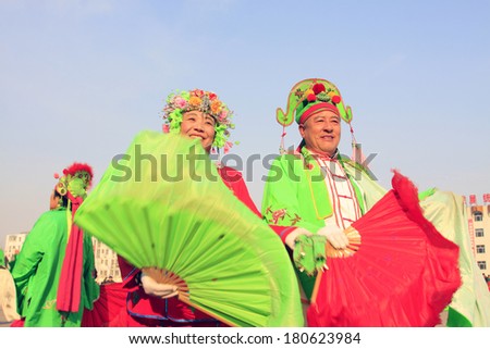 LUANNAN COUNTY - FEBRUARY 11: People wearing colorful clothes, performing yangko dance in the street, during the Chinese Lunar New Year, February 11, 2014, Luannan County, Hebei Province, China.
