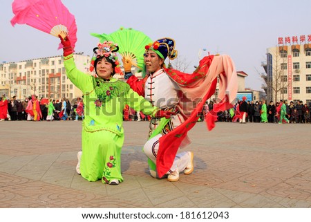 LUANNAN COUNTY - FEBRUARY 13: People wearing colorful clothes, performing yangko dance in the street, during the Chinese Lunar New Year, February 13, 2014, Luannan County, Hebei Province, China.
