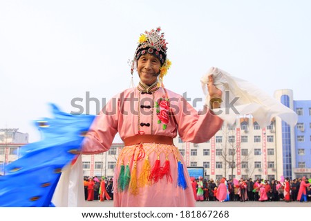 LUANNAN COUNTY - FEBRUARY 15: Old man wearing colorful clothes, performing yangko dance in the street, during the Chinese Lunar New Year, February 15, 2014, Luannan County, Hebei Province, China.