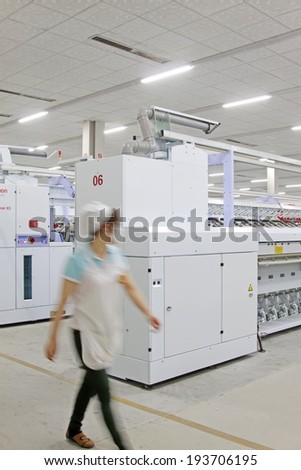 LUANNAN - MAY 4: woman hurried by spinning production line in a yarn factory, on May 4, 2014, Luannan county, hebei province, China.