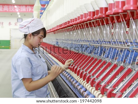 LUANNAN, CHINA - MAY 4: Women were spinning production line operation in production workshop, on May 4, 2014, Luannan county, hebei province, China.