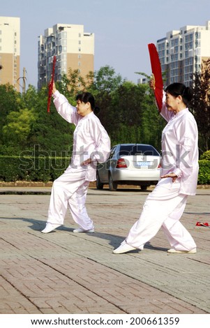 LUANNAN COUNTY - JUNE 14: A group of old people were performing Tai chi chuan on the gym in the square, on june 14, 2014, LuanNan county, hebei province, China