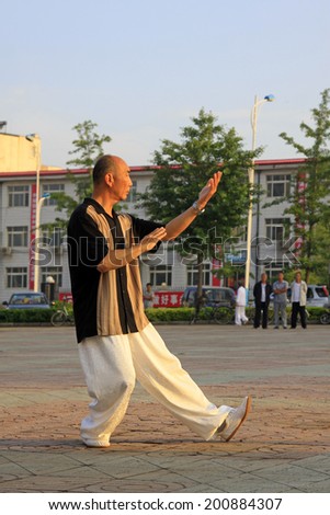 LUANNAN COUNTY - JUNE 14: A man was performing Tai chi chuan on the gym in the square, on june 14, 2014, LuanNan county, hebei province, China
