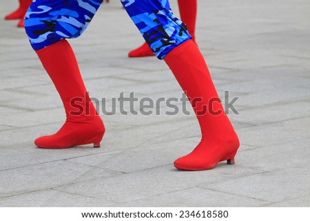 Blue camouflage trousers and red boots, closeup of photo