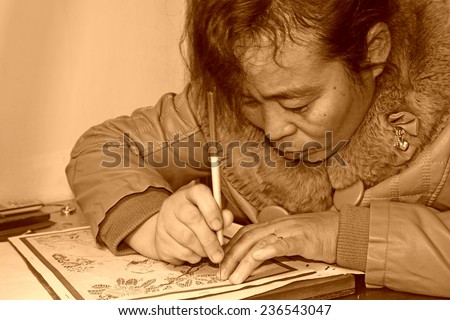 FUCHENG - DECEMBER 8: female craftsmen used kedao production of paper cutting, on december 8, 2013, fucheng, hebei province, China.