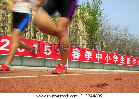 LUANNAN COUNTY - APRIL 15: long-distance runner running before a giant bulletin board, April 15, 2015, Luannan County, Hebei Province, China