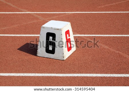 Wooden track number mark on the plastic runway, closeup of photo