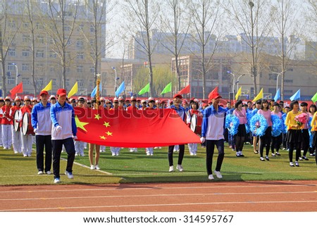 LUANNAN COUNTY - APRIL 14: China flag and flag bearer at the athletics meeting, April 14, 2015, Luannan County, Hebei Province, China