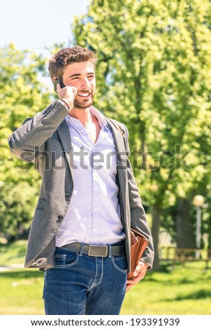 Young business man in the park with smartphone having a break after a working day texting sms messages - Modern concept of nature mixed with human urban and metropolitan life