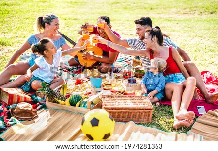 Multiracial families having fun together with kids at pic nic barbecue party - Joy and love life style concept with mixed race people toasting juices with children at park - Warm bright filter Foto stock © 