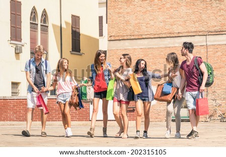 Group of happy best friends with shopping bags in the city center - Tourists walking and having fun in the summer around the old town - University students during a break in a sunny day