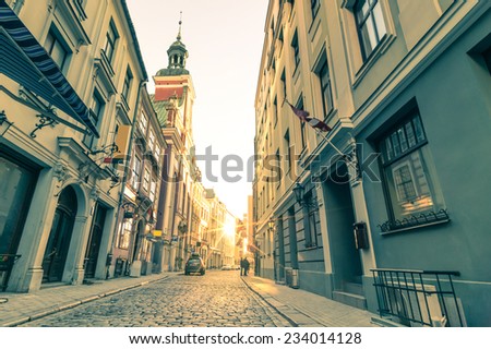 Vintage retro travel postcard of a narrow medieval street in old town Riga at sunset with sun reflection - Latvia - European capital of culture 2014