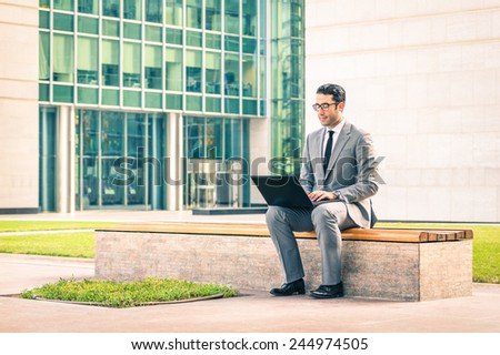 Young hipster business man sitting with laptop at business center - Modern concept of technology wifi connection - Handsome businessman working outdoors with computer connected with wireless internet