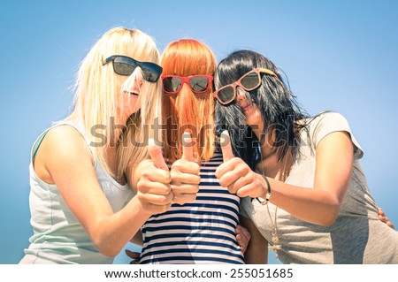 Group of young girlfriends with focus on colored funny hair and sunglasses - Concept of friendship and fun in the summer expressing positivity with thumbs up - Best friends sharing happiness together