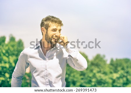 Happy young business man at park with smartphone having a break after a working day - Modern concept of nature mixed with human urban and metropolitan lifestyle - Bright vintage nostalgic look
