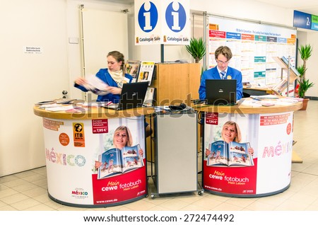 BERLIN, GERMANY - MARCH 8, 2014: information center at ITB Travel Trade Show in the fairgrounds of Messe Berlin. Slight blurred motion on the two employees due to long exposure.