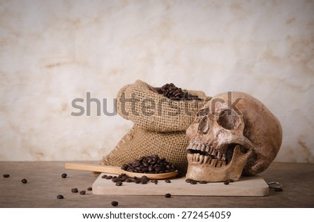 coffee bean on scoop ,coffee bean on bag  and human skull on wood background