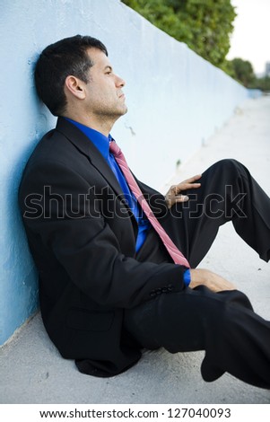 Business man sitting down after losing his job depressed and worried