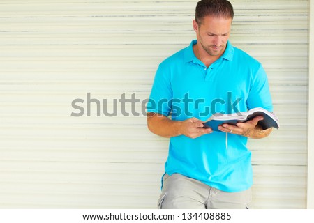 Man with Tattoo Reading The Bible