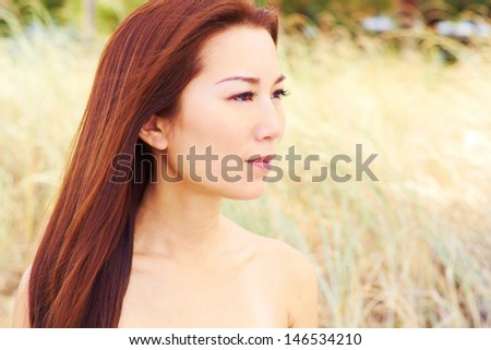 Beautiful young asian fashion model with clear skin and long silky flowing hair in a serene atmosphere