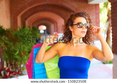 beautiful young woman with shopping bags wearing sunglasses. Horizontal Shot.