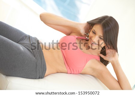 Portrait of young woman smiling while doing physical exercises.
