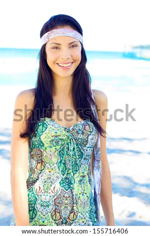 Beautiful happy young multi ethnic fashion model near the sea with clear skin and long silky flowing hair with copy space