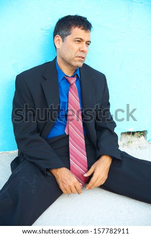 business man sitting down after losing his job depressed and worried.