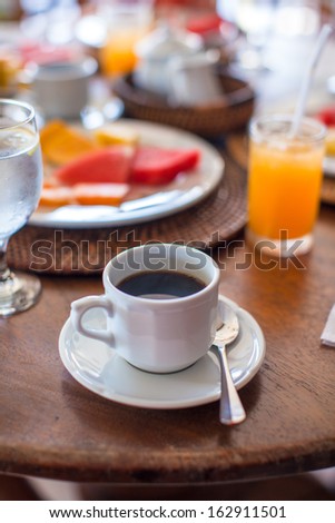 Black coffee, juice and fruits for breakfast at a cafe in the resort