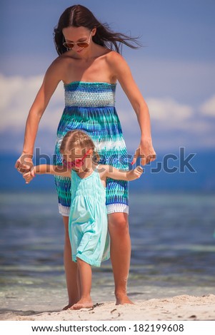 Little girl and young mother on tropical beach in desert island