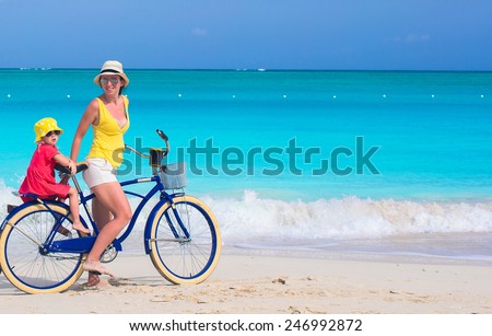 Young family riding bicycles on tropical beach