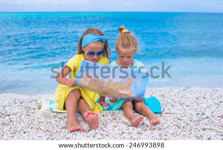 Adorable little girls with map of island on tropical beach