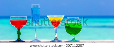 Colorful exotic tasty cocktails in outdoor cafe background turquoise sea at exotic resort