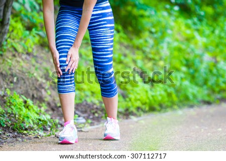 Female athlete suffering from pain in leg while exercising outdoors