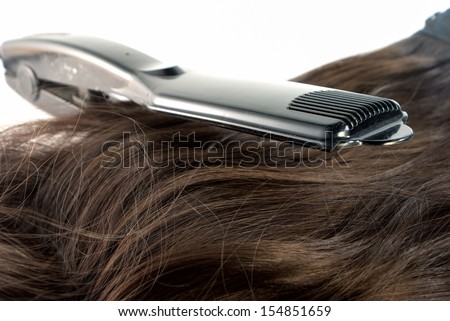 Hair straighteners and hair on white background